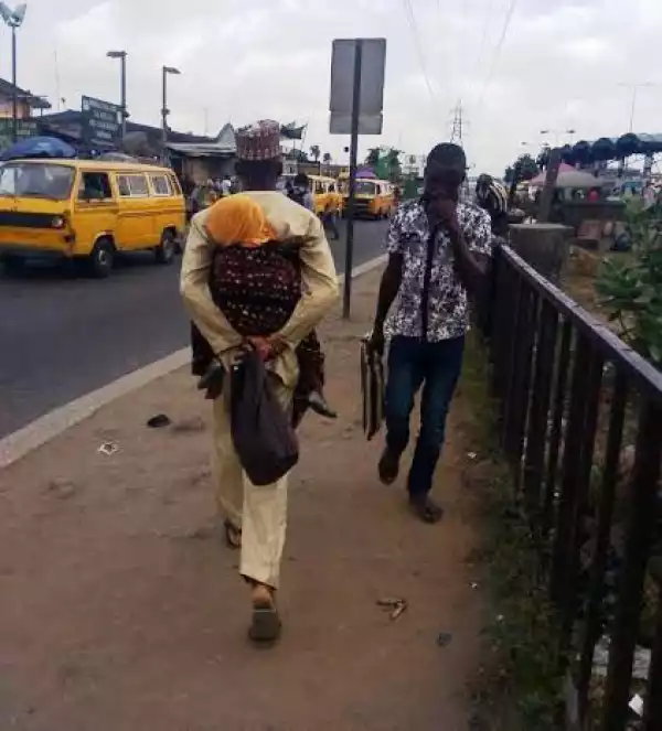 Husband Spotted Backing Baby In Lagos [See Photo]